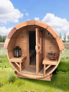 a wooden circular cabin in the middle of a field at Glamping Camping NixHoeve in Genderen