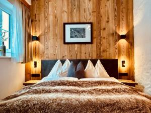 a bedroom with a bed with a wooden wall at Sonn-Alm Chalet-Apartments in Bichlbach