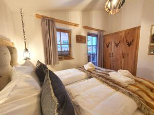 ein großes Bett mit weißer Bettwäsche und Handtüchern darauf in der Unterkunft Alpen Chalets Zell am See in Niedernsill