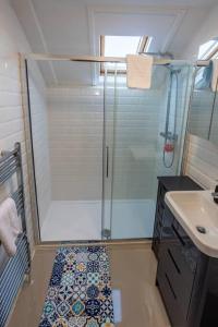 baño pequeño con ducha y lavamanos en 2BR Dorset Charming Apartment in Towncenter, en Christchurch