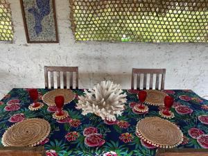 una mesa con dos sillas con platos y cuencos en Namahamade Lodge Restaurante & Beach Bar, en Mossuril