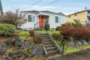 ein weißes Haus mit einer roten Tür in der Unterkunft Beacon Hill Abode in Seattle