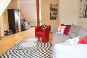 a living room with a couch and a red chair at Apartament 007B pod Śnieżką in Karpacz