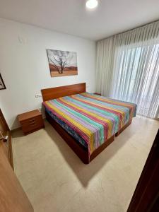 - une chambre avec un lit et une couverture colorée dans l'établissement Marina Dor Primera Linea, à Oropesa del Mar