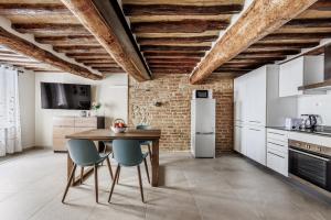 cocina con mesa de madera y sillas azules en Il Mezzanino, en Siena