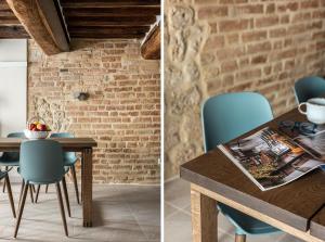einen Esstisch mit Stühlen und eine Ziegelwand in der Unterkunft Il Mezzanino in Siena