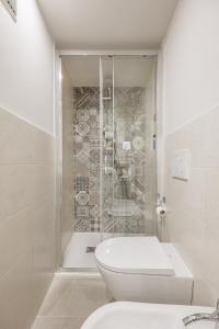 a white bathroom with a toilet and a shower at Il Mezzanino in Siena