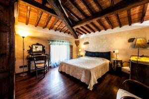 a bedroom with a bed and a desk in a room at Fonte Del Castagno in Sinalunga