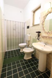 y baño con 2 aseos, lavamanos y espejo. en Da Termini, en Marsala