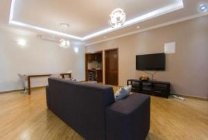 a living room with a couch and a flat screen tv at Ká Jackson Bilene in Vila Praia Do Bilene