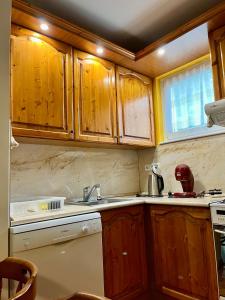 a kitchen with wooden cabinets and a sink at Emília apartman in Balatonszemes +13 photos