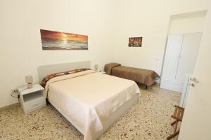 1 dormitorio con 1 cama en una habitación blanca en Da Termini, en Marsala