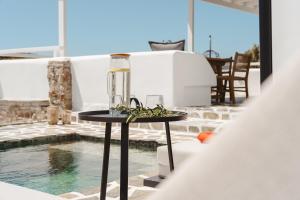 a table with a glass jar on it next to a pool at Elaia Retreat Naxos in Vívlos