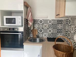 a kitchen with a sink and a microwave at Studio RDC 35m2 Plein centre in Foix