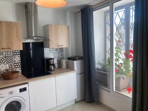 a kitchen with a washing machine and a window at Studio RDC 35m2 Plein centre in Foix