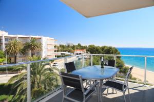 d'un balcon avec une table et des chaises bleues et l'océan. dans l'établissement UHC Panoramic Family Complex, à Miami Platja