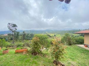 a view of a field with trees and a house at Mirkeland- Cabaña in Ráquira