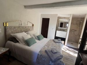 - une chambre avec un grand lit blanc et des oreillers dans l'établissement PROCHE GRASSE - LE MAS de la MADONETTE, à Spéracèdes