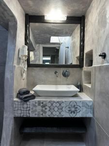 a bathroom with a sink and a large mirror at Unique Traditional Stone house in Skiathos