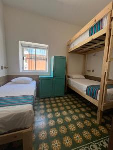 1 dormitorio con 2 literas y ventana en Hostal Doña Cuca en Capilla de Guadalupe