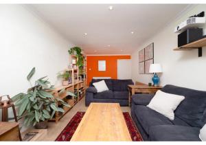 una sala de estar con 2 sofás azules y una mesa. en chic 3-BR home welll located in Islington en Londres