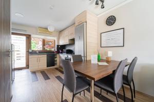 cocina y comedor con mesa de madera y sillas en B48 Duplex, en Törökbálint