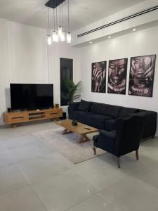 ein Wohnzimmer mit einem Sofa und einem Flachbild-TV in der Unterkunft וילת צאלים in Jerocham
