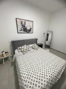 a bedroom with a bed with a black and white comforter at וילת צאלים in Yeroẖam