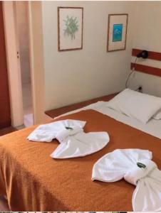 dos toallas blancas sentadas encima de una cama en Alugamos para grupos, en Vargem Alta
