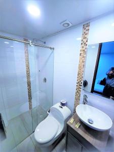 a bathroom with a toilet and a sink and a shower at Hotel Kristal Ferial in Bogotá +70 photos