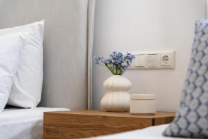 un vase blanc avec des fleurs violettes assises sur une table dans l'établissement Elaia Retreat Naxos, à Vívlos