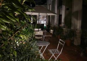 un patio con mesa, sillas y sombrilla en Posada Gotan en Buenos Aires