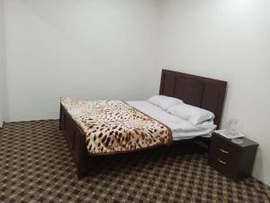 a bedroom with a bed with a leopard print blanket at Yazgar Residency Skardu in Skardu