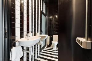 een zwart-witte badkamer met 2 wastafels en een toilet bij Eulalias Lodges Barcelona in Barcelona +42 foto's