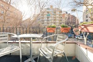 uma mesa e cadeiras numa varanda com plantas em Eulalias Lodges Barcelona em Barcelona