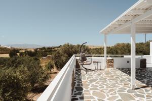 a white pergola on a patio with a view of the desert at Elaia Retreat Naxos in Vívlos