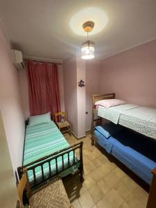 1 dormitorio con 2 camas, ventana y lámpara de araña en Appartamento Da Marina, en Scalea