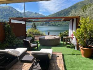 eine Terrasse mit einem Whirlpool, einem Tisch und Stühlen in der Unterkunft Room with a View in Cima