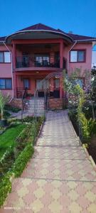 a pink house with a walkway in front of it at Vila Natasa&Sofia in 2 Mai