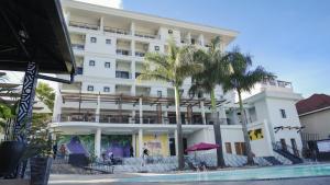 吉佳利的住宿－KIGALI DELIGHT HOTEL &APARTMENTS，一座白色的大建筑,前面有棕榈树