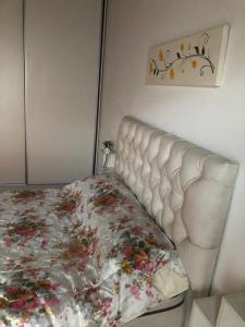 Una cama blanca en un dormitorio con una manta de flores. en Alquiler por Día Alca!!!! en Viedma
