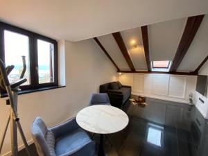 una sala de estar con una mesa y sillas en PENTHOUSE RIJEKA CENTAR, en Rijeka