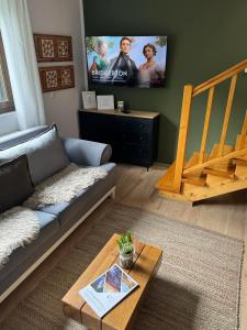 sala de estar con sofá y TV de pantalla plana en Casa Rustik Nyaraló, en Praid