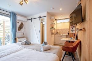 a bedroom with a large bed and a kitchen at Bed en Bike Strûnen op Texel in Den Burg