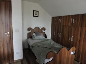 a bedroom with a bed and a wooden cabinet at Four Season Apartament in Valea Adîncă +5 photos