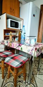 a kitchen with a table with chairs and a microwave at Four Season Apartament in Valea Adîncă