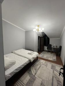 een slaapkamer met een bed en een eetkamer met een tafel bij Гостиница 888 in Koshtegirmen