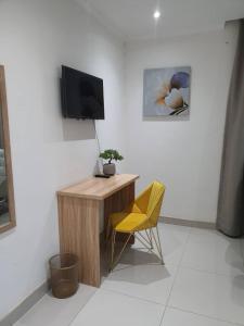 un bureau et une chaise jaune dans la chambre dans l'établissement House At Eight, à Jwaneng
