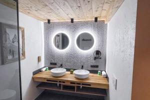 uma casa de banho com dois lavatórios e dois espelhos em Naturlodge Ladis im Sommer inkl Super Sommer Card em Ladis