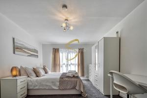 ein weißes Schlafzimmer mit einem Bett und einem Kronleuchter in der Unterkunft Luxe 3 Bed Central Nottingham in Nottingham
